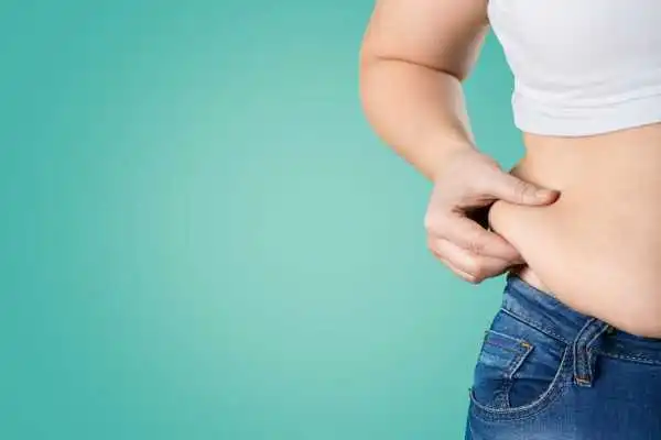 Image of woman pinching her love handles to show weight gain Handsworth Wood